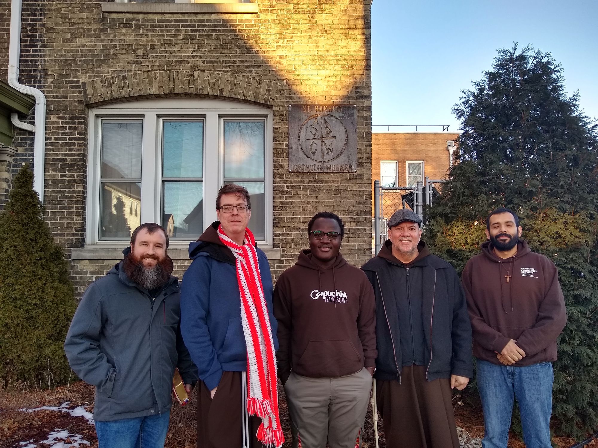 Capuchin postulants, Br. David Hirt and Br. Celestino Aria, Delegate to the Capuchin General Minister for the North American Pacific Capuchin Conference outside the St. Bakhita Catholic Worker House in Milwaukee.