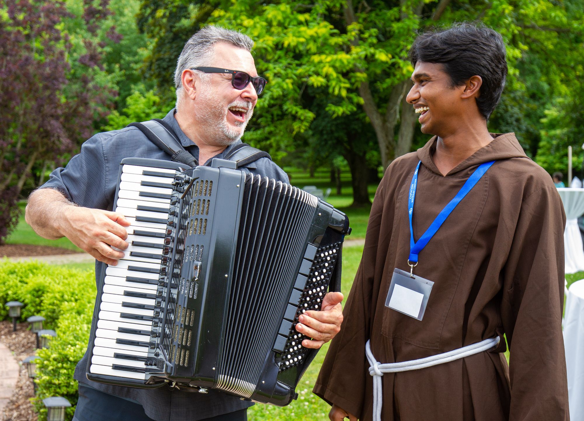  A strolling accordionist performs as Br. Julius looks on at the 2022 A Gouda Evening.
