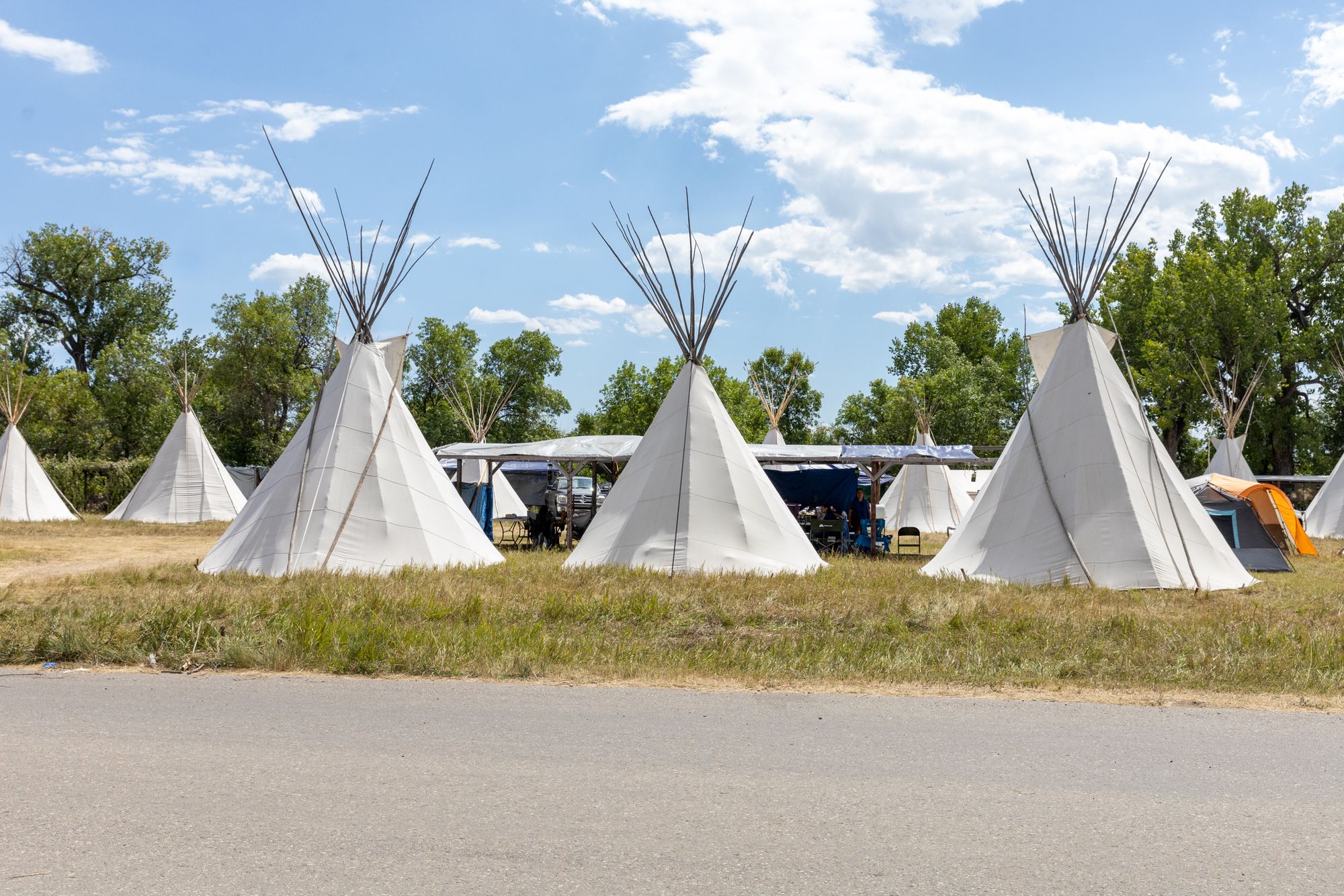 A color landscape photograph of teepees at the Crow Fair in Crow Agency, Montana.